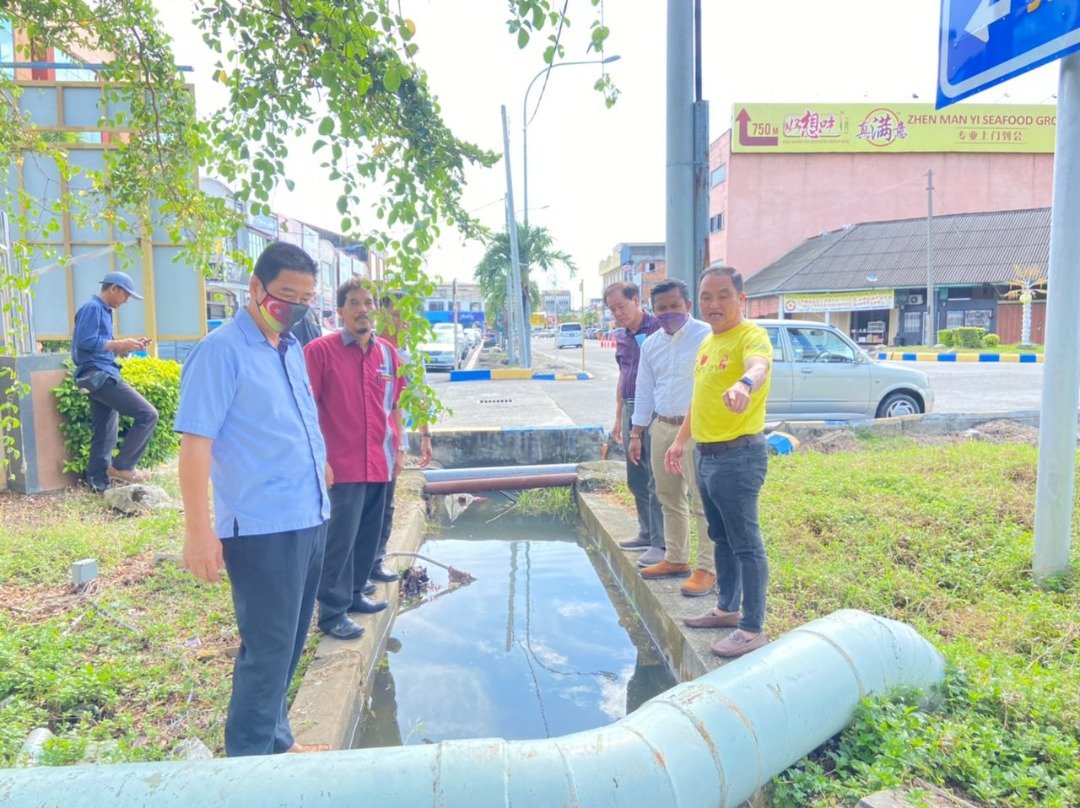 黄瑞林（左起）聆听水利灌溉局官员，讲解提升水闸的计划。