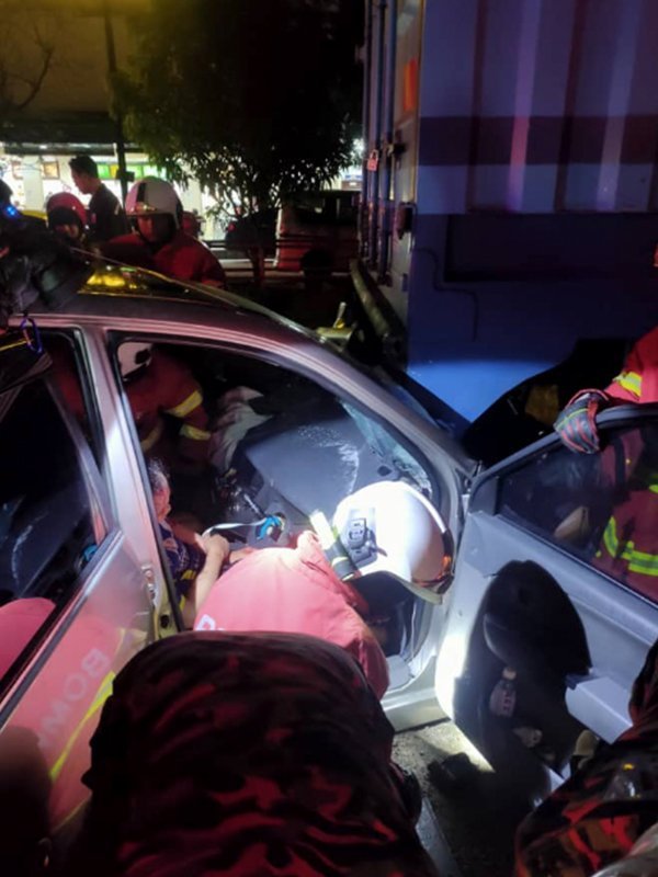 轿车司机座上有1名女子被夹受困。