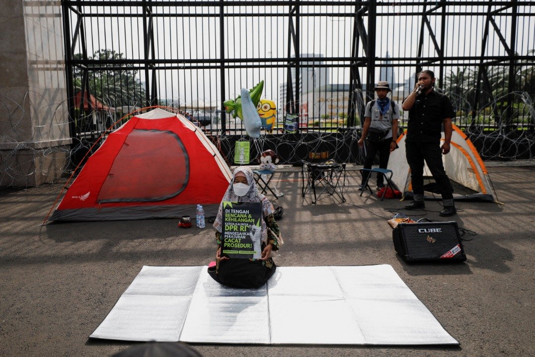 在印尼国会通过备受争议的《刑法修正草案》后，有活跃人士在国会大厦外扎营抗议，并发表演说。（图取自路透社）
