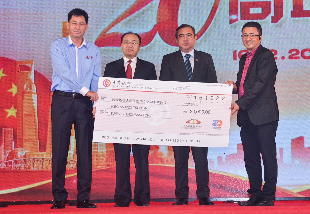 在中国驻马大使欧阳玉靖（左2）和大马交通部长陆兆福（左3）见证下，张敏（左）代表大马中资企业总商会捐助吉隆坡循人华小家教协会2万令吉。
