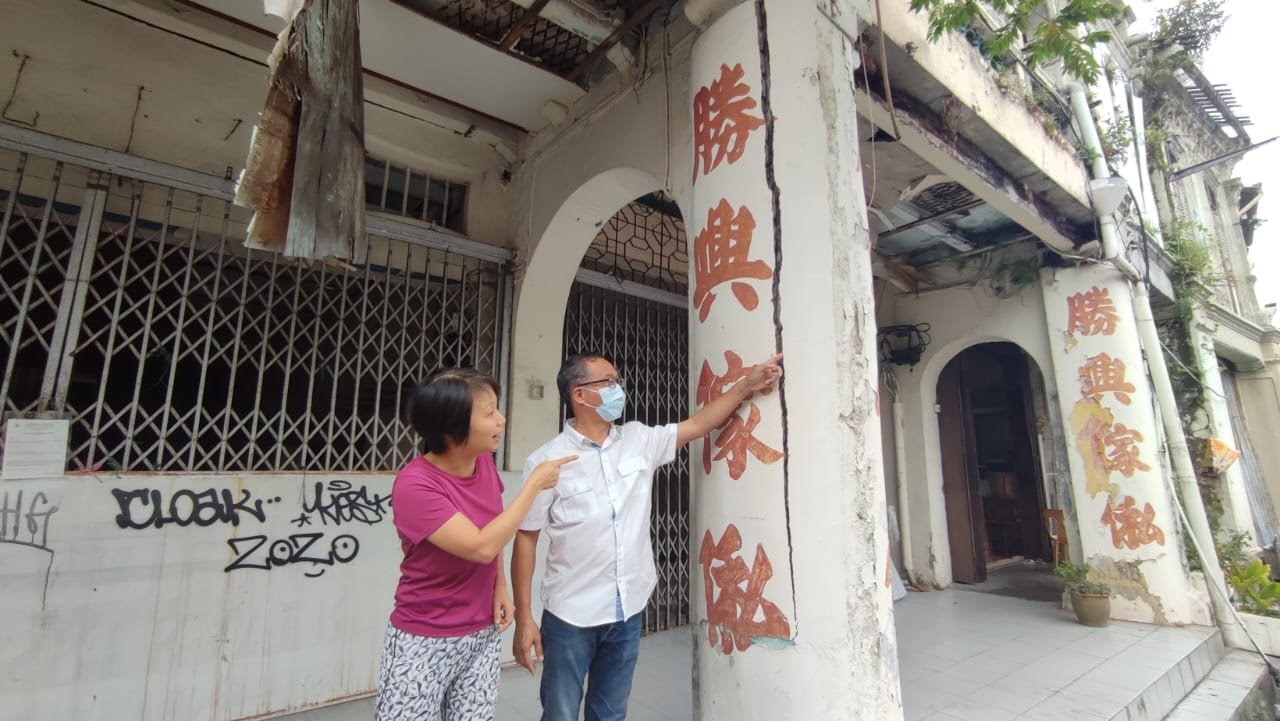 黄翠菁（左起）向刘志俍投诉老屋梁柱的裂痕越来越大，危及行人安全。