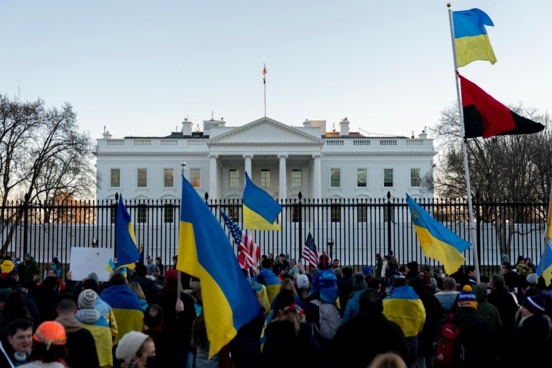 一群人当地时间周日在美国白宫外挥舞著乌克兰国旗。（图取自法新社）
