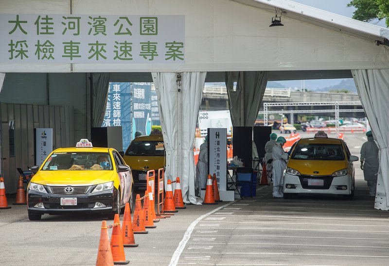 桃园机场疫情扩大，台北市政府要求防疫计程车司机在周六和周日须全数进行PCR检测。许多司机及民众周日上午前往大佳河滨公园车来速筛检站采检。（图取自中央社）