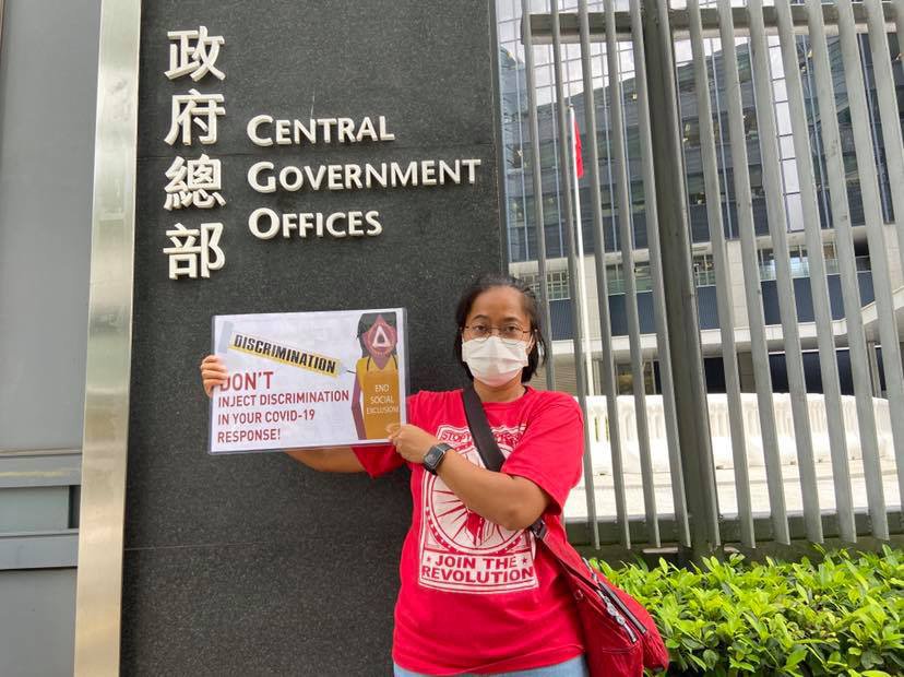 2021年6月，印尼移工工会主席Sringatin在香港中区政府办公司外举起横幅，抗议歧视性防疫政策。