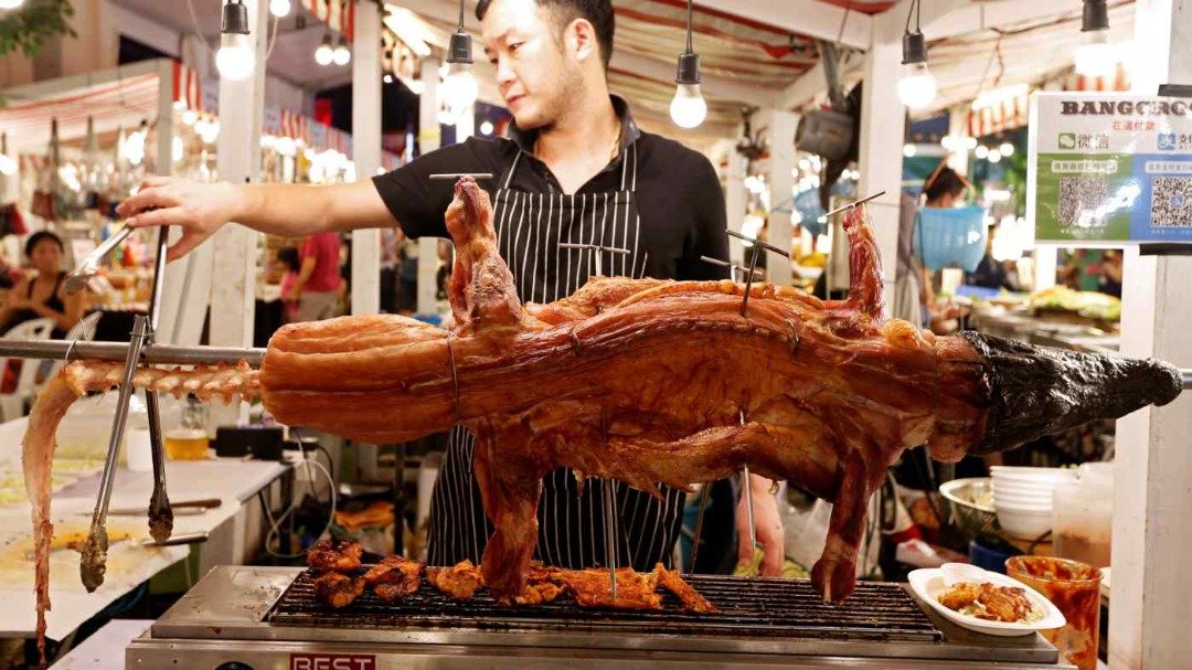 泰国猪价自去年中开始狂飙，当地民众开始改用其他食材替代，令鳄鱼肉需求激增。图为2019年，曼谷一个市场摊位，摊贩在烤鳄鱼售卖。（图取自路透社）