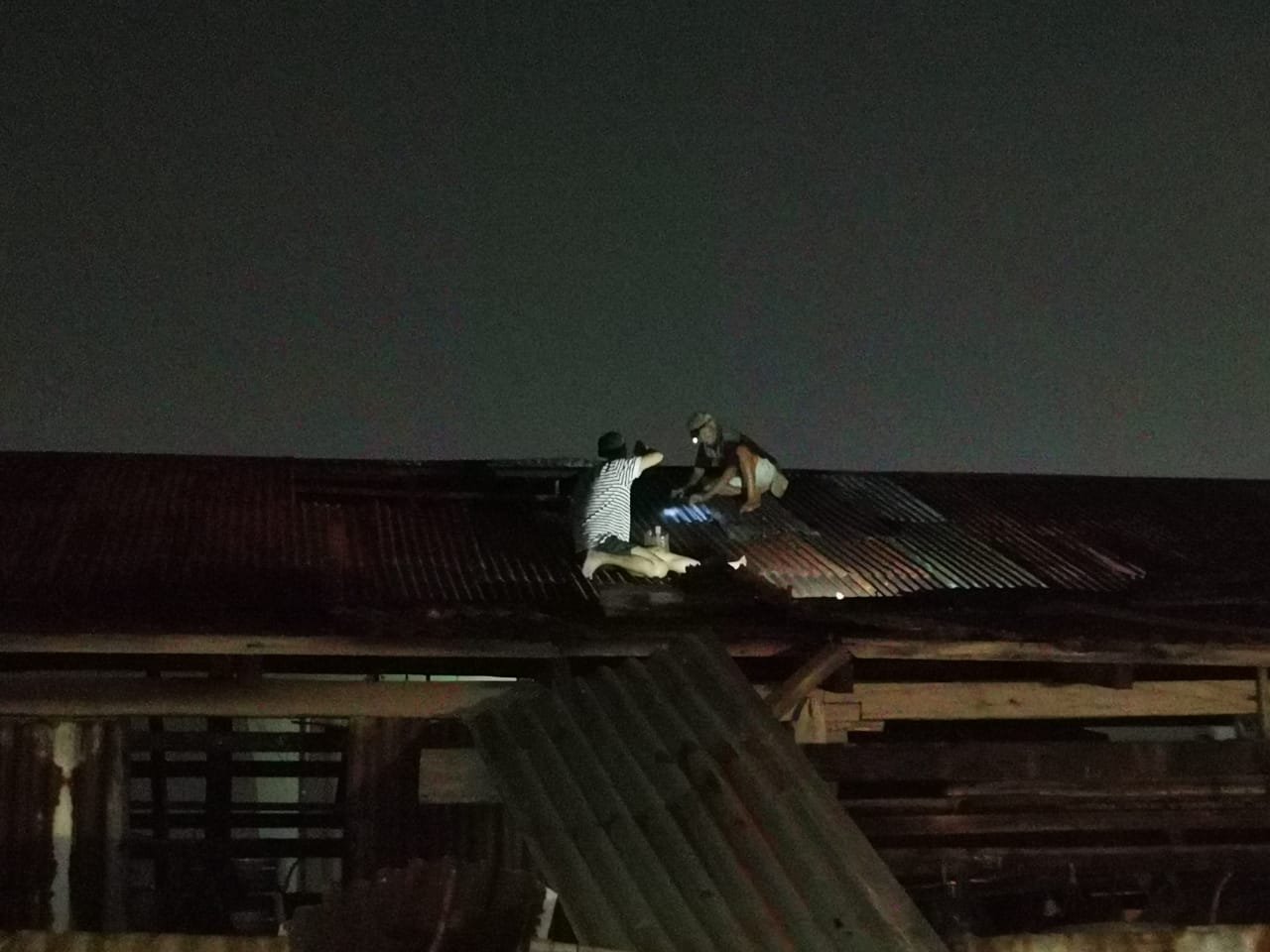 部分灾民爬上屋顶抢修屋顶。