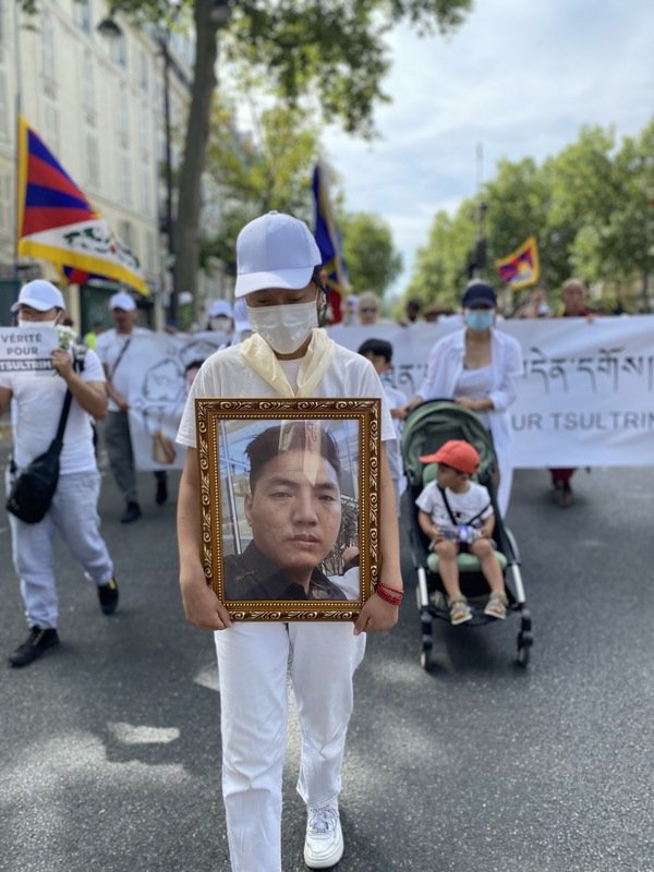走在队伍最前头为受害藏人楚臣的遗像，游行过程非常和平。主办单位表示，目的就是希望呼吁法国司法还受害者一个公道。（图取自中央社）