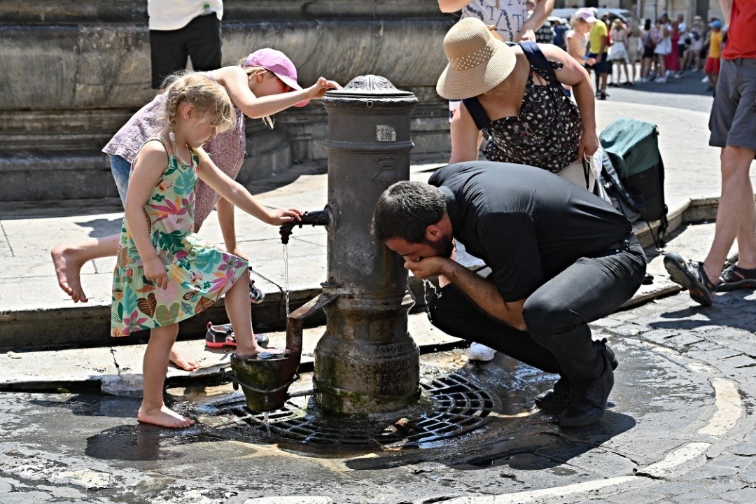 热浪席卷欧洲，多国录得破纪录的高温。在意大利罗马，游客们当地时间周二在万神殿前的喷泉喝水消暑。（图取自法新社）