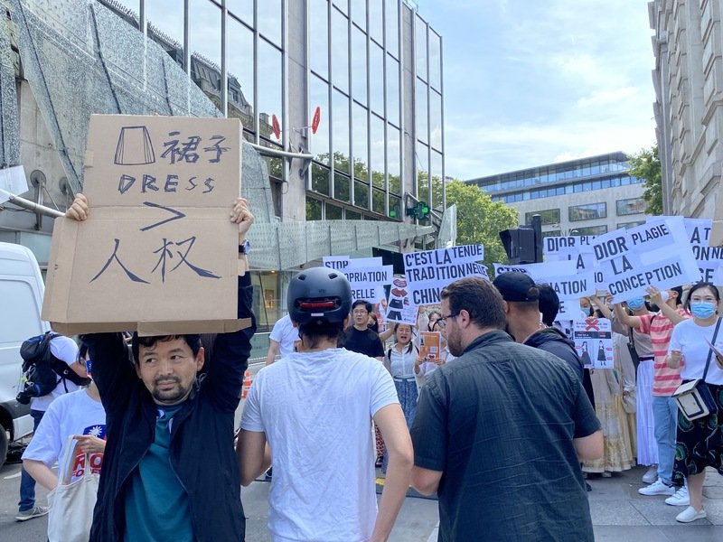 在抗议现场，也有另一批中国籍反示威者高举标语，讽刺示威者把裙子看得比人权重要。（图取自中央社）