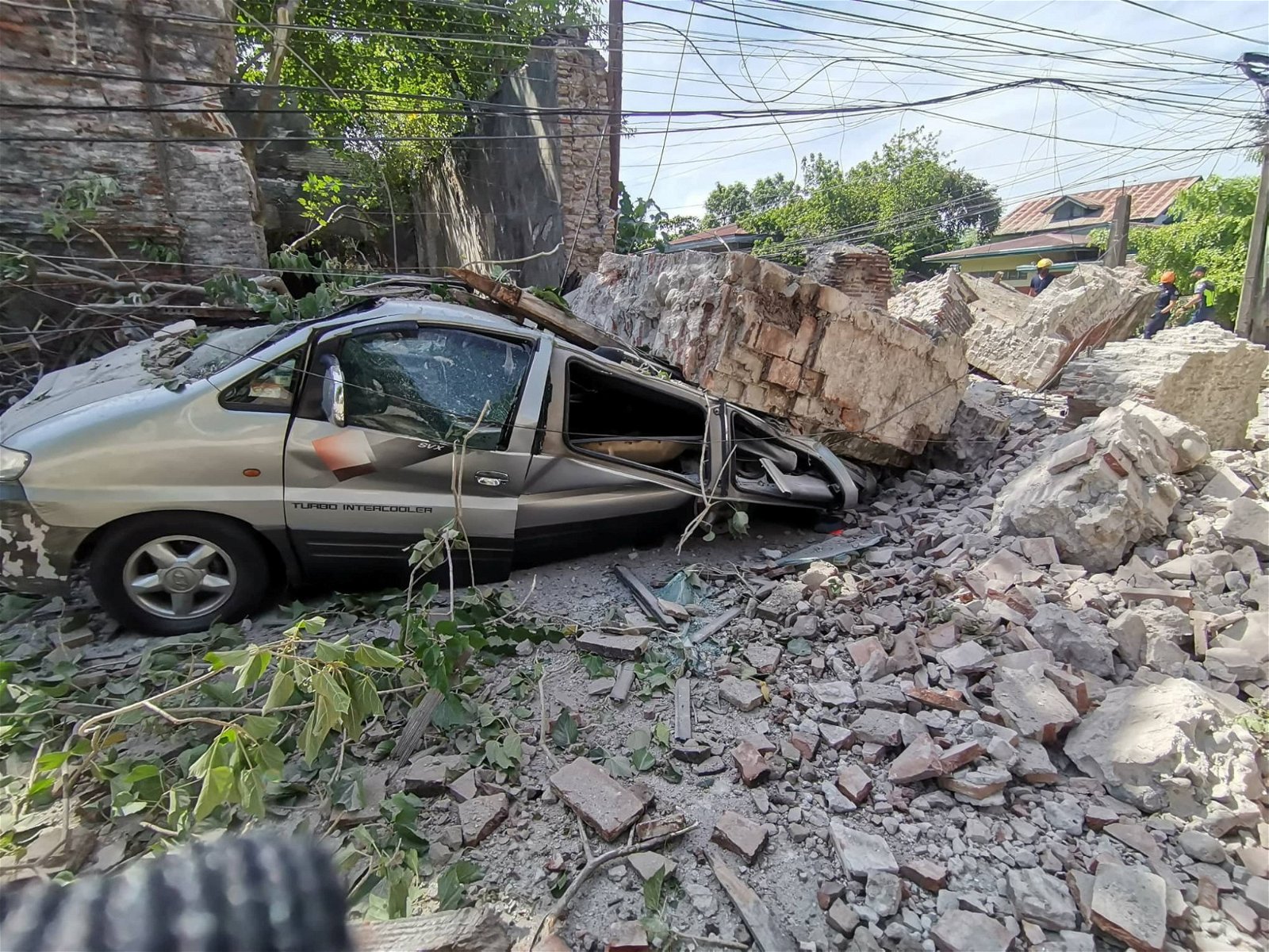 在吕宋岛西海岸的维甘市，坍塌的墙体将车子压得会不成形。（图取自消防局公共信息服务/路透社）