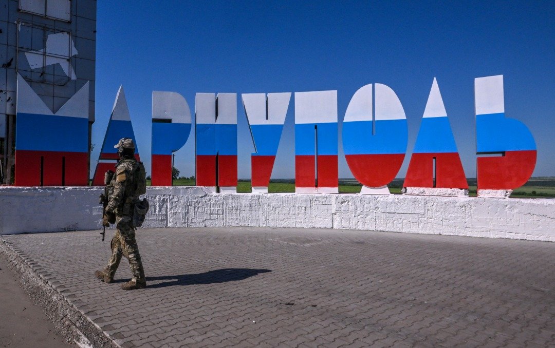 在马里乌波尔入口处一个写有“马里乌波尔”的城市标志，该标志被油漆上俄罗斯国旗颜色。（图取自法新社）