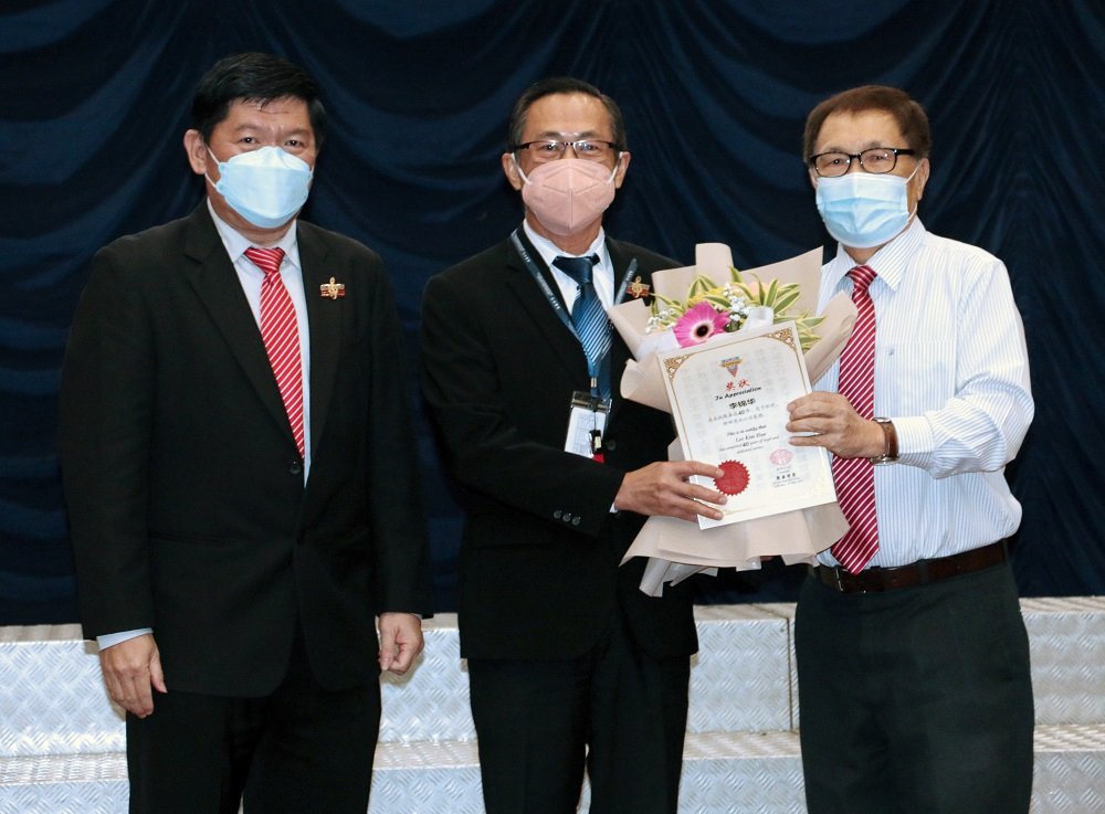 荣获40年服务奖的李锦华老师与拿督李平福董事长（左）和苏进存校长（右）合影。