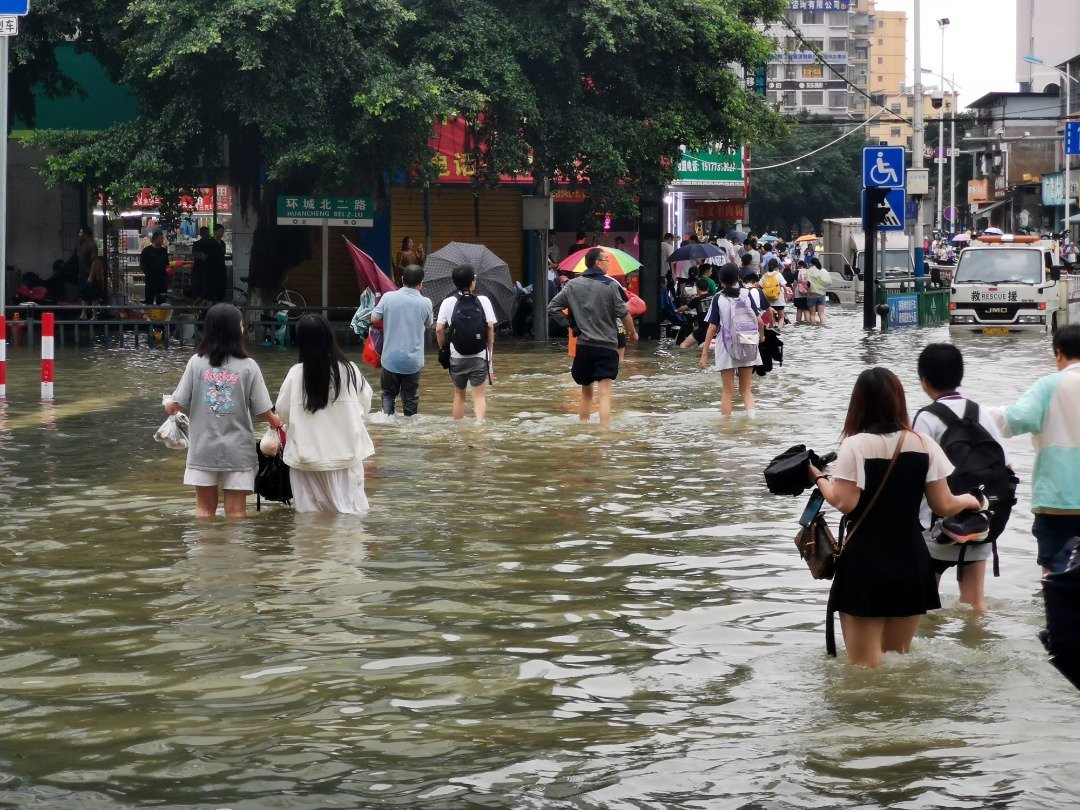 在广西桂林市环城北二路，民众周二涉水出行。当天，桂林市强降雨持续，市区多地路段积水严重，街道成“河”。（图取自中新社）