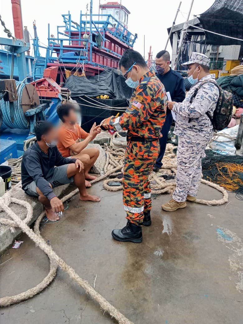 搜救员向2名渔民了解事发经过。
