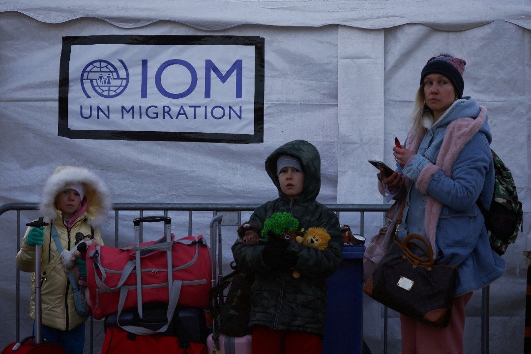 一名母亲带著6岁与9岁的孩子逃离乌克兰，周日抵达波兰和乌克兰边境的梅迪卡检查站。（图取自路透社）