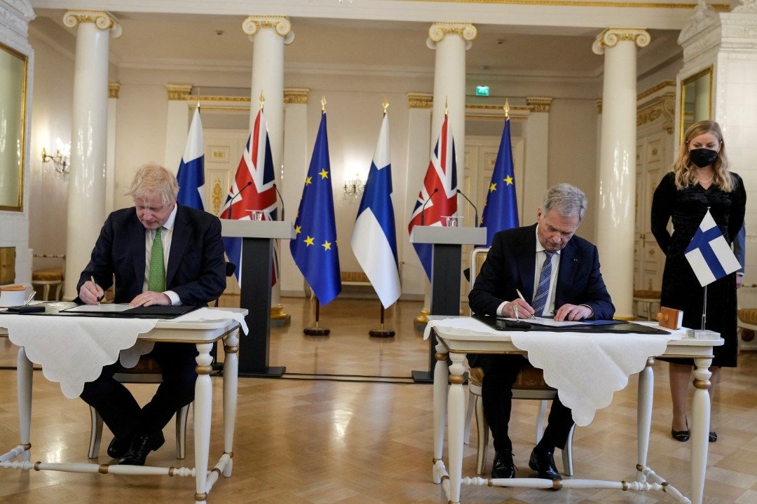 英国首相约翰逊（左）与芬兰总统尼尼斯托签署安全宣言，承诺如果任何一个国家受到攻击，另一方将通过各种方式提供支援。（图取自路透社）