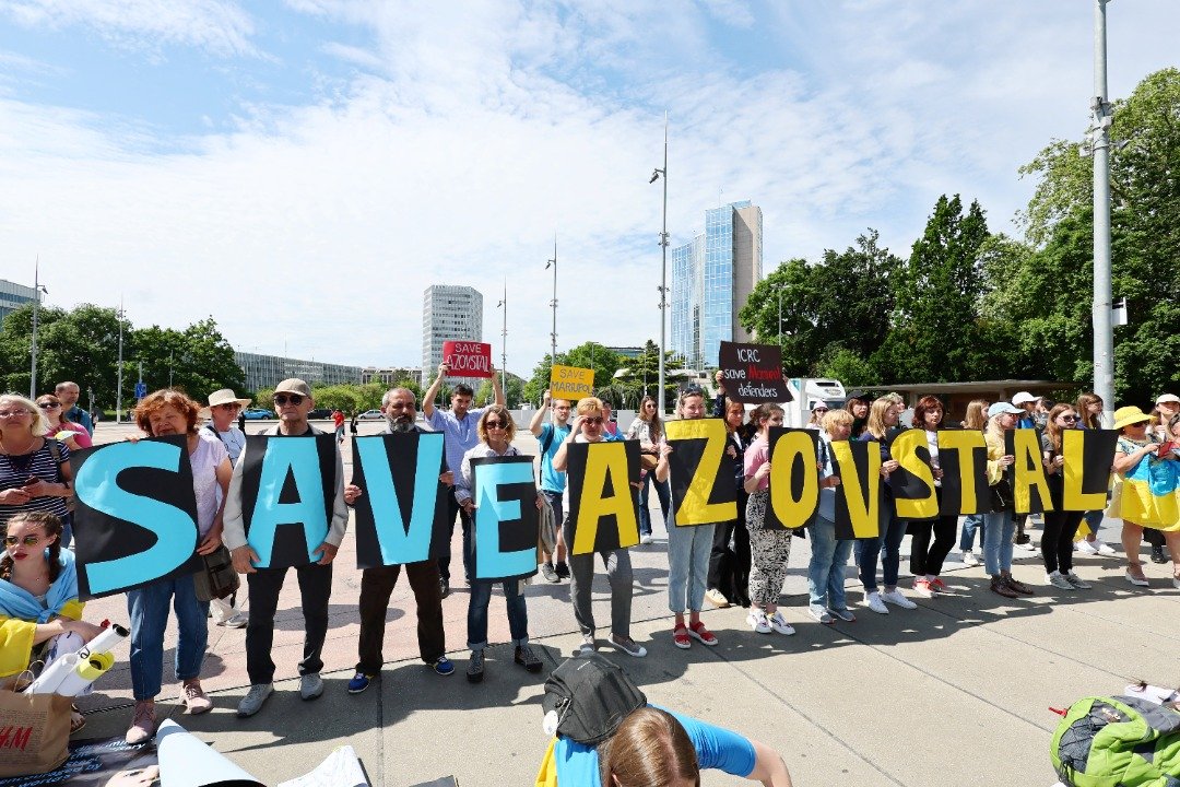周四在瑞士日内瓦的联合国人权理事会外，有许多示威者拿著代表乌克兰的黄、蓝色标语牌，写著“救救马立波、救救亚速钢厂”。（图取自路透社）
