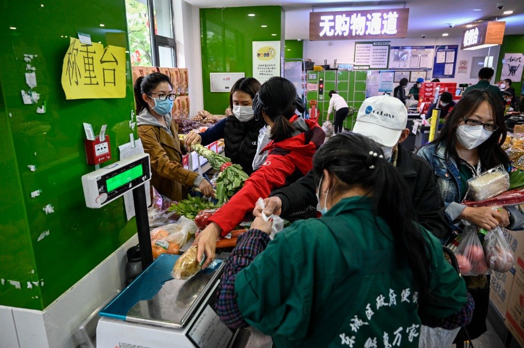 周四下午，网上有传言称北京将进入3天“静默”，北京地区多个生鲜电商平台出现运力不足，超市也涌现人潮。图为当天北京一家超市市民购物的情况。（图取自法新社）