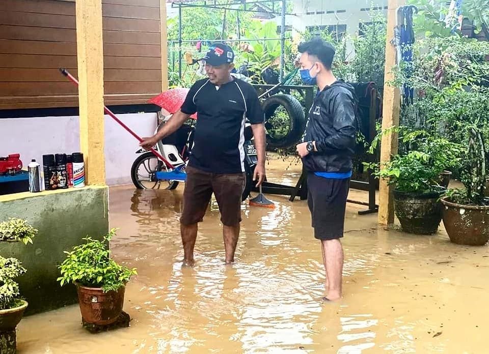 蔡建文（右）向马来甘榜村民了解水灾情况。（图取自蔡建文面子书）