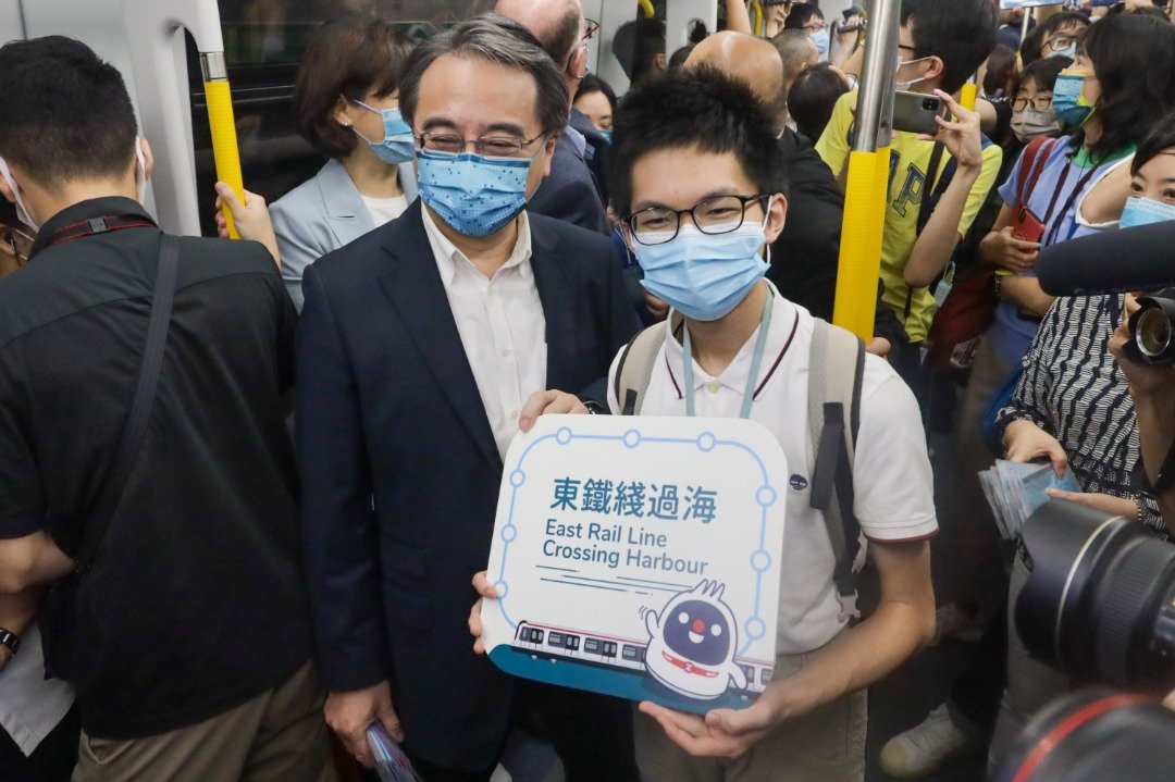 港铁行政总裁金泽培（左2）与乘坐首日特别班次列车的香港市民合照。（图取自中新社）