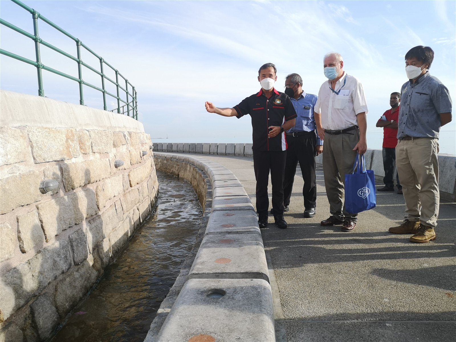 尤端祥（左）与法兰切斯哥（左2）等人，向媒体解释低层步道设计，其用意主要凸显拥有超过200年历史的海堤墙。