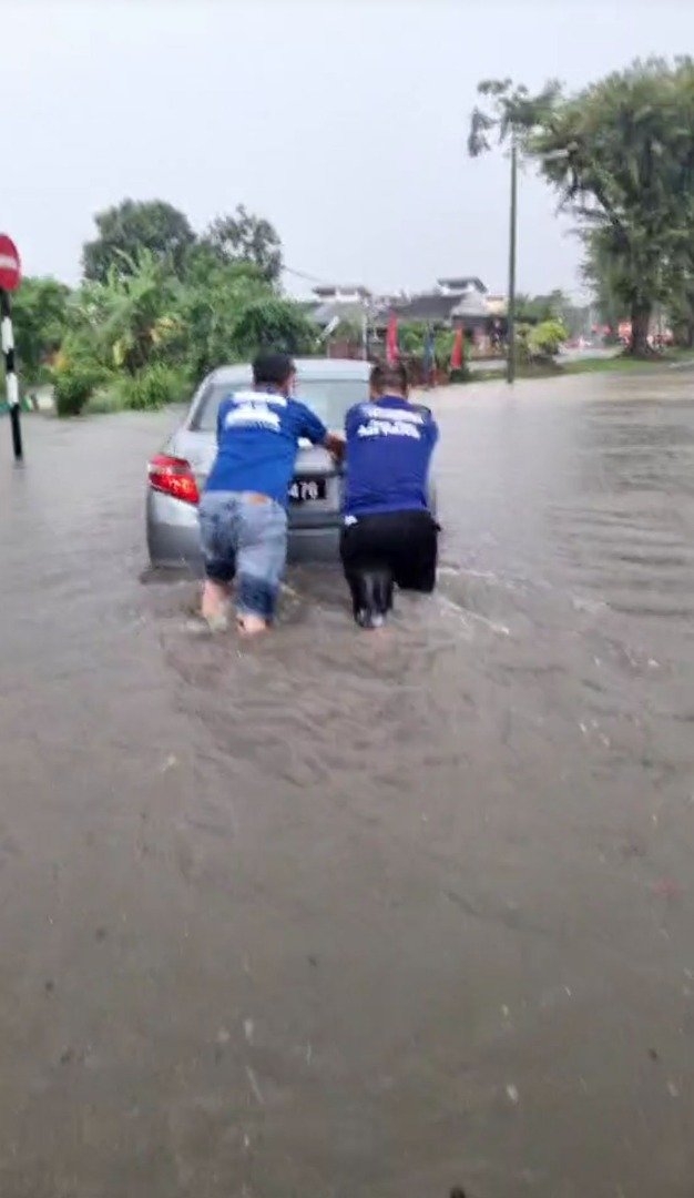陈扬邦及团队合力把水中故障的轿车移到安全的地方。