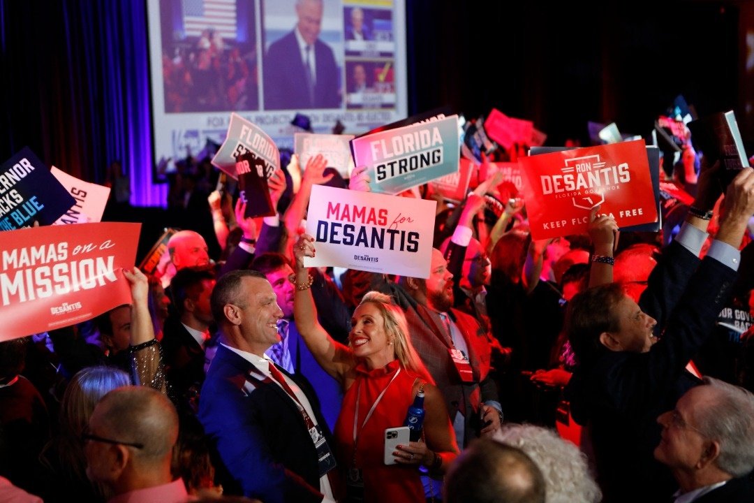 8日晚间，佛州州长德桑蒂斯的支持者在坦帕市的选举夜派对上，通过屏幕观看德桑蒂斯打败民主党挑战者，成功连任后开心庆祝。（法新社）