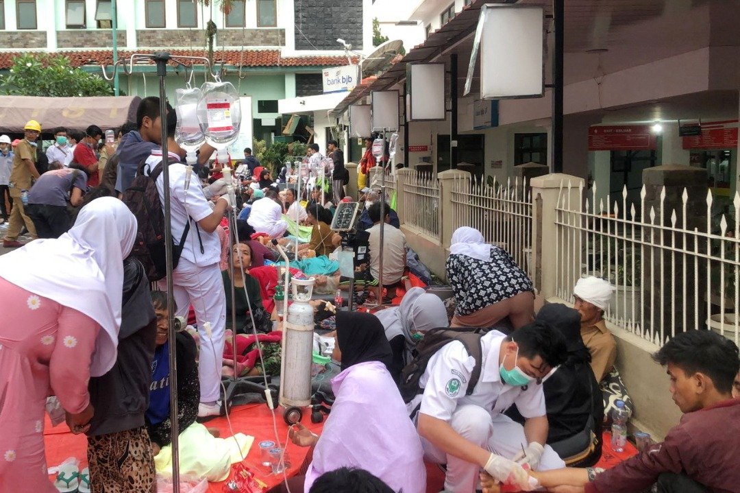大量地震受害者在医院停车场外接受抢救。（图取自Antara Foto/路透社）