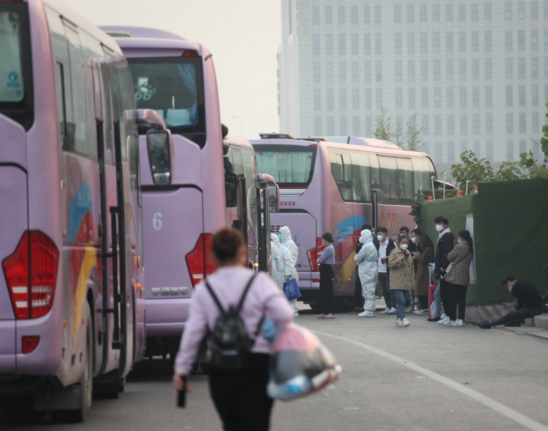 10月31日，郑州航空港区富士康园区有返乡意愿的工人，陆续登上回家的巴士。图为接返乘车点，巴士依次排开等候富士康返乡员工登车。（图取自中新社）