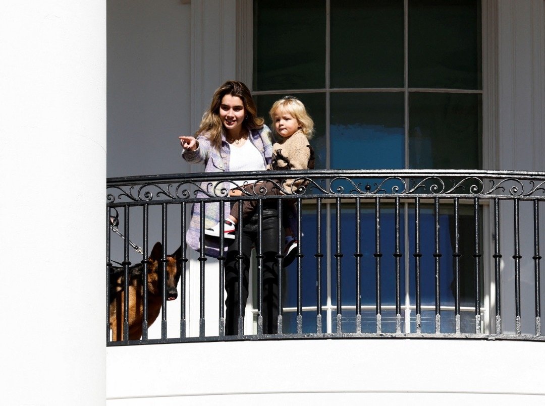 美国总统拜登的孙女和孙子，还有德国牧羊犬“司令”从白宫阳台上观看赦免火鸡的仪式。（图取自路透社）