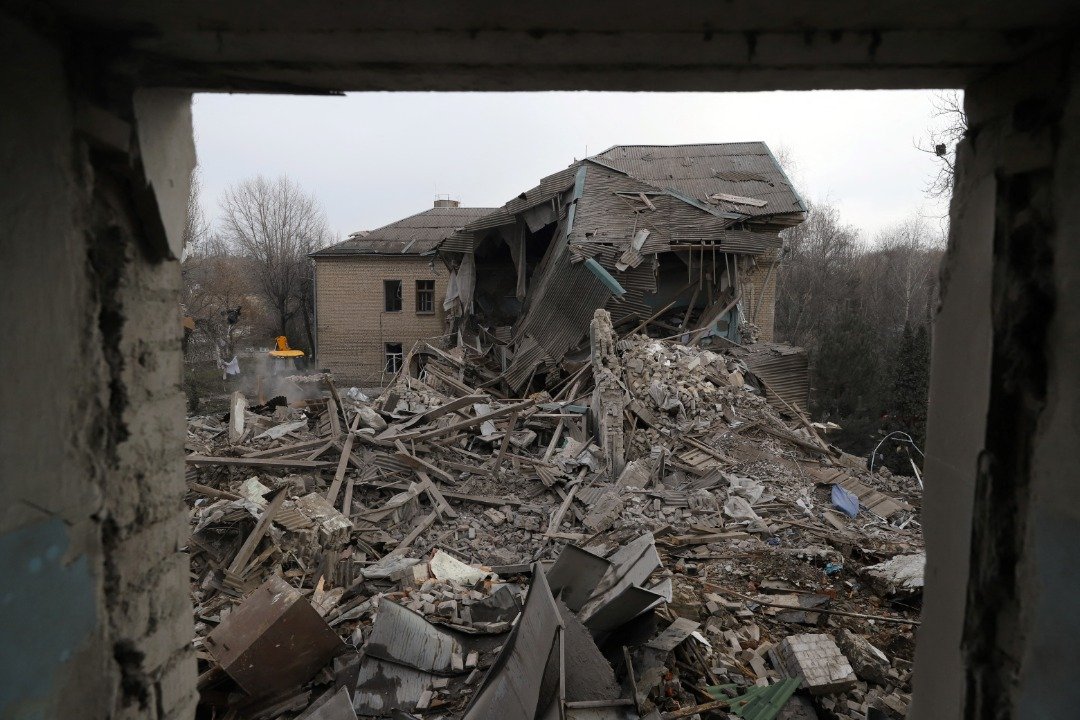 在南部扎波罗热的Vilnyansk镇，俄军导弹在周三击中一座两层楼的产科建筑，导致一名新生婴儿死亡。图为救援人员在清理产科建筑的废墟。（图取自法新社）