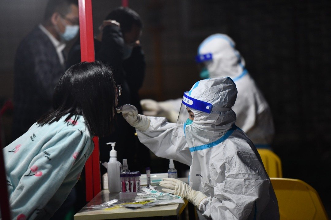 在四川成都，工作人员周三在为市民进行核酸检测。自2022年11月23日零时起至27日24时，成都连续5天在18个区（市）县开展大规模核酸检测工作。（图取自中新社）