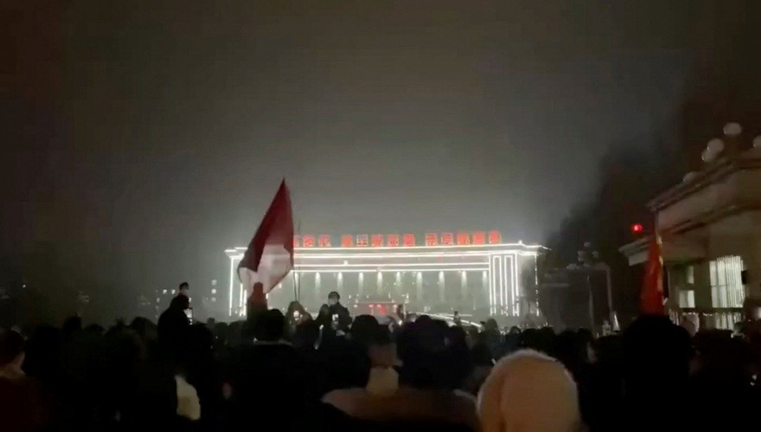 根据视频截图，人们聚集在一处广场上，高唱著中国国歌中“起来，不愿做奴隶的人们”的歌词。（图取自路透社）