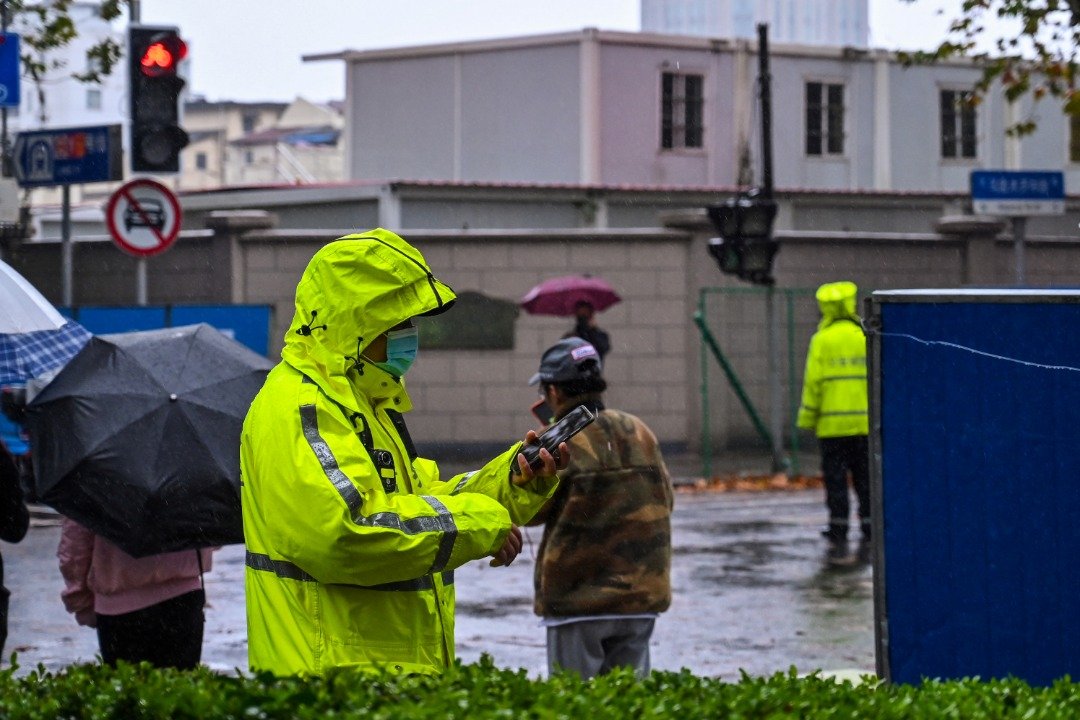 在上海的乌鲁木齐路，周二随处可见穿著黄色雨衣站岗的警察。（图取自法新社）