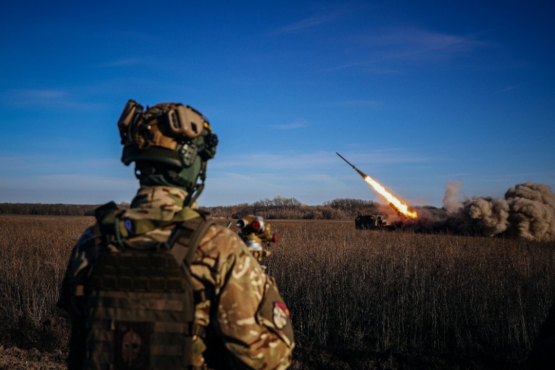 在乌克兰东部前线，一名乌克兰士兵周二观看一架自行式220毫米多管火箭炮“Bureviy”射向俄罗斯阵地。（图取自法新社）