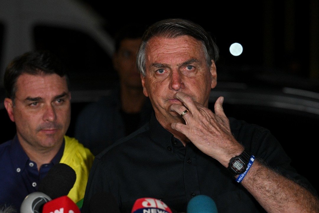 争取连任的巴西总统博索纳罗（右）在巴西利亚得知选举结果后发表谈话，左为他的儿子弗拉维奥。（图取自法新社）