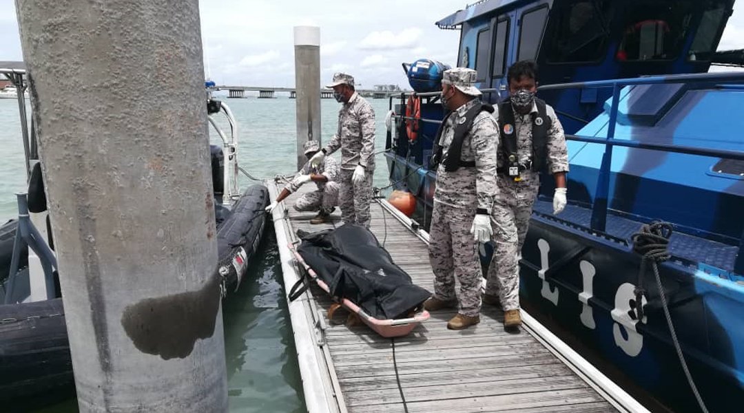 槟州海事执法机构人员将死者遗体打捞上岸。