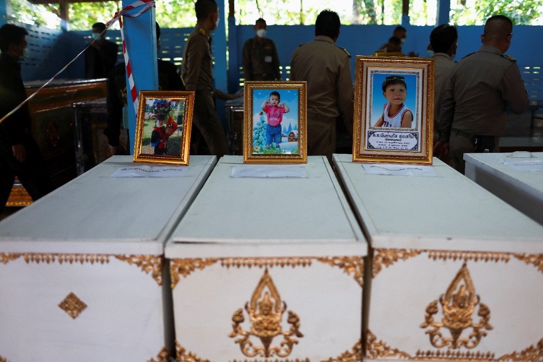 寺庙里排列整齐的棺材上，放着年幼受害者的照片，场面令人心酸。（图取自路透社）