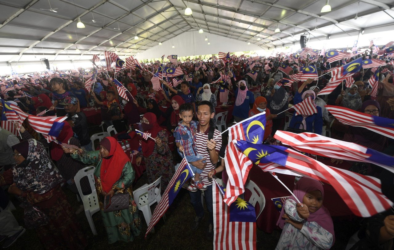 约1万5000人出席“大马一家”与民聚餐活动，随著《辉煌条纹》歌曲响起，纷纷挥动国旗。