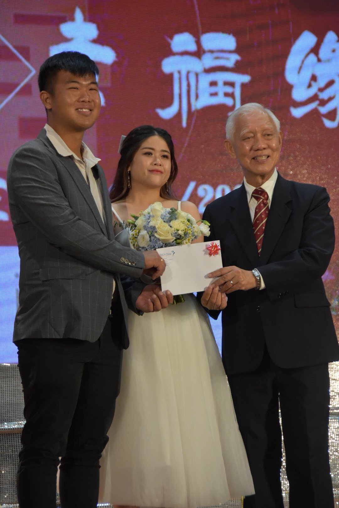 方家盛（左起）与邱秀盈获选最佳服装奖之一，两人从何朝东手中接领奖品。