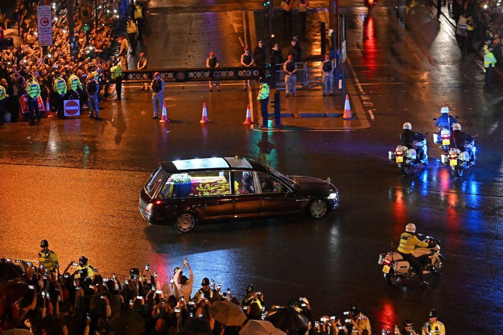 英女王灵柩被送往白金汉宫途中，道路两旁挤满了在雨中迎接的民众。（图取自法新社）