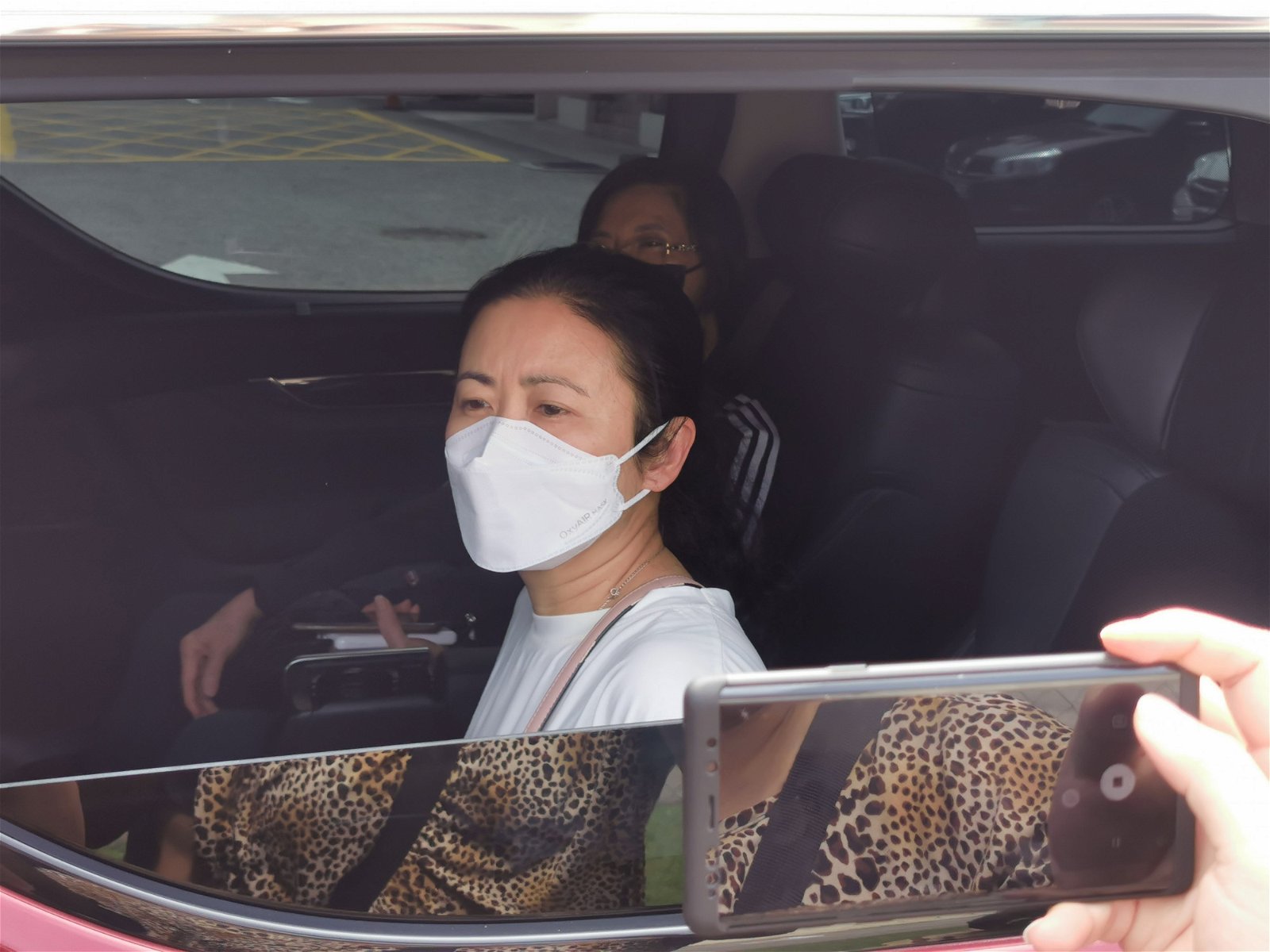 死者遗孀梁女士在离开太平间时，打开车窗接受媒体访问。