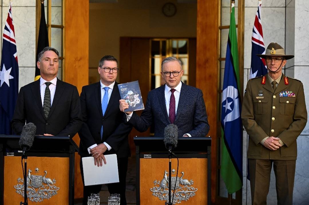 澳洲副总理兼国防部长马尔斯（左起）、澳洲国防工业部长康罗伊、澳洲总理阿尔巴尼斯、和澳洲国防军总司令坎贝尔，周一在澳洲堪培拉国会大厦发布“国防战略评估”报告后，于新闻发布会上对媒体发表讲话。（图取自澳联社/路透社）