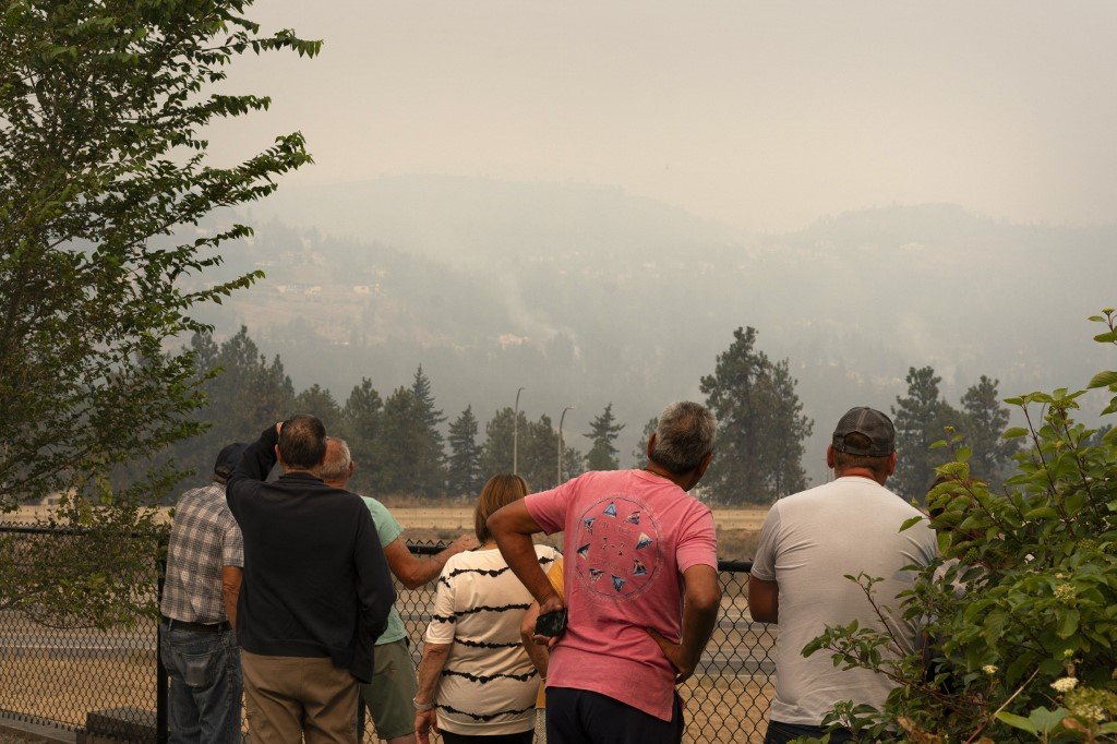 在加拿大不列颠哥伦比亚省的西基洛纳，人们当地时间周六（19日）看著不断燃烧的“麦克杜格尔溪”野火。（图取自法新社）