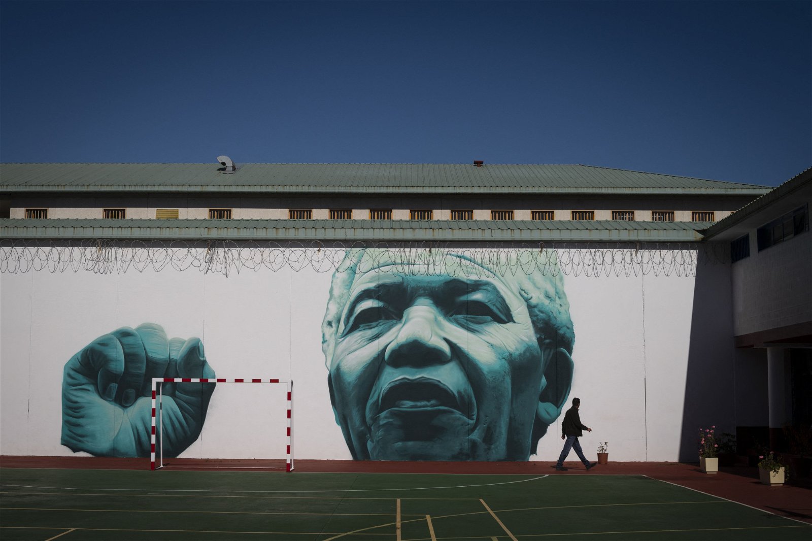 这座监狱的曼德拉牢房关有55名囚犯，其中20人为女性。图为监狱院子的墙上画有一幅前南非总统曼德拉的壁画。（图取自法新社）