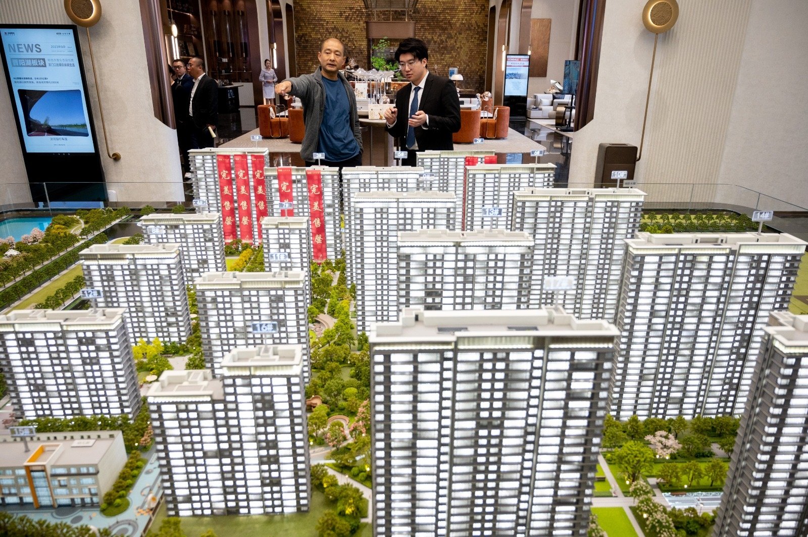10月20日，山西省太原市一售楼部内，销售人员为市民推介商品房户型。（图取自中新社）