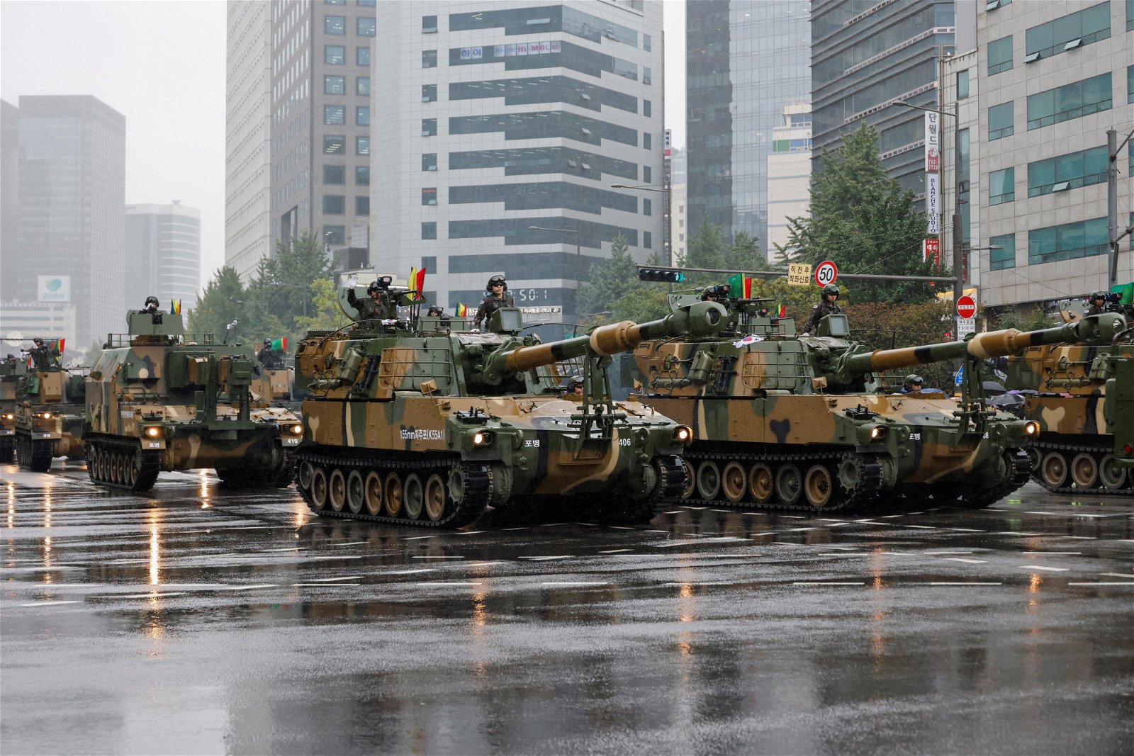 韩国军人乘坐军车，参加韩国武装部队日75周年巡游。（图取自路透社）