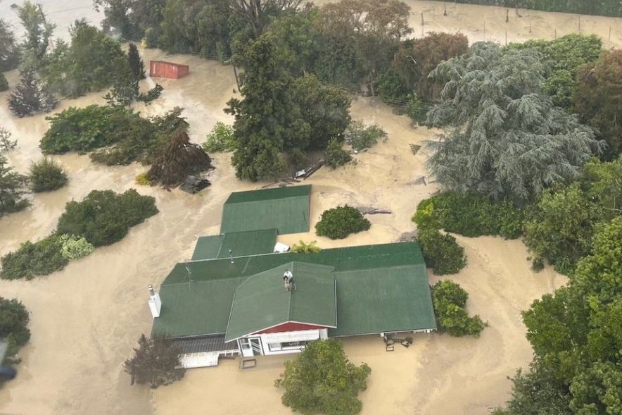 热带气旋“加布丽埃勒”在纽西兰北岛引发洪灾，房子泡在水中。图为一架NH90直升机，在内皮尔营救受困屋顶上的灾民。（图取自纽西兰国防军/路透社）
