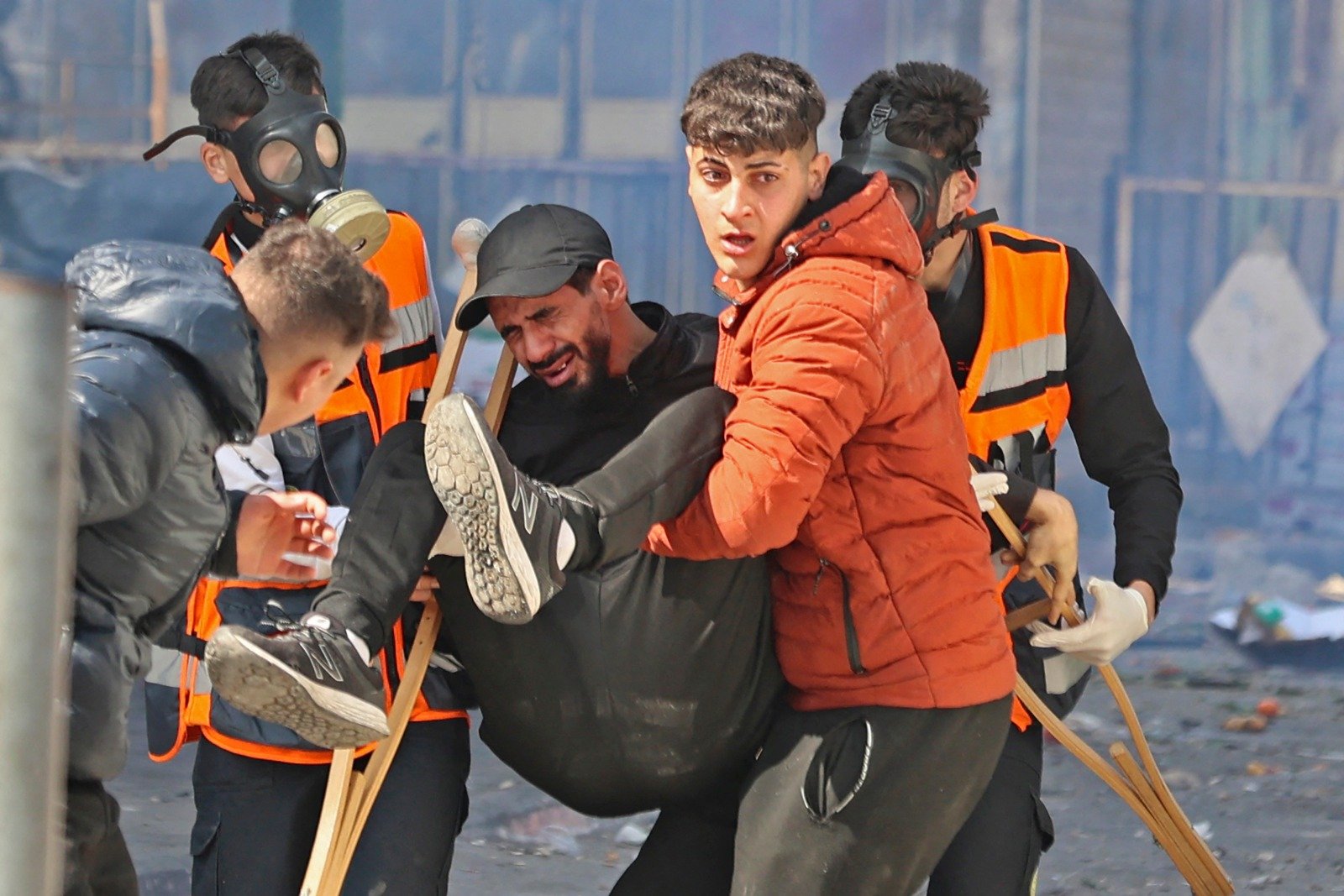 在纳布卢斯的冲突爆发期间，一群巴勒斯坦人抬走一名受伤的男子。（图取自法新社）