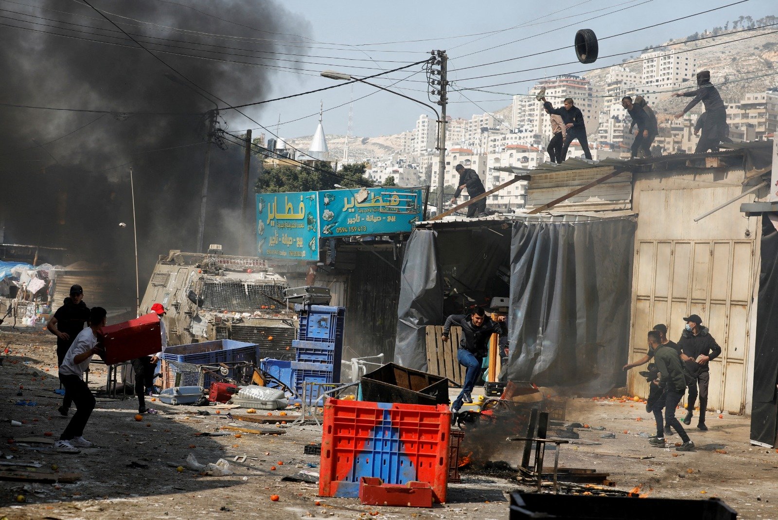 以军在周三突袭约旦河西岸城市纳布卢斯时，当地的巴勒斯坦人用轮胎、石块等物品反击。（图取自路透社）